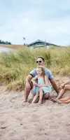 Family sitting on the beach at Pease Bay