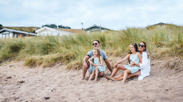 Family sitting on the beach at Pease Bay