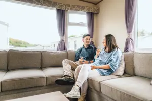 Couple relaxing in a caravan at Scoutscroft Leisure Park