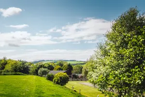 Green hills, trees and the clubhouse at Thurston Manor