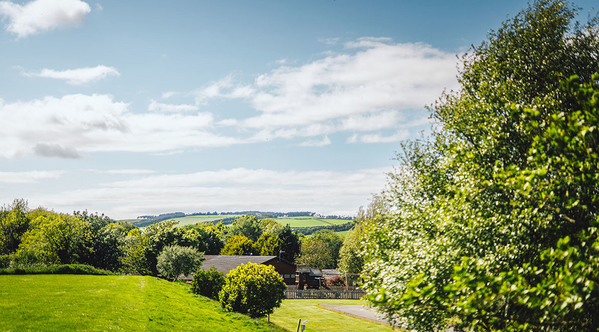 Green hills, trees and the clubhouse at Thurston Manor