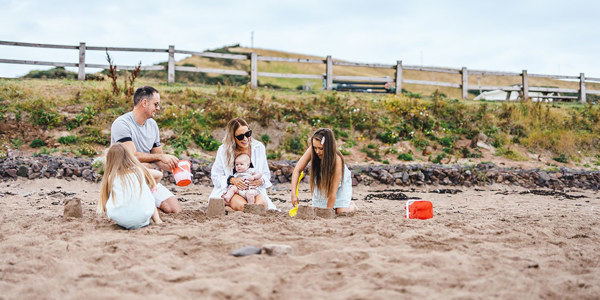 Family building sandcastles on the beach at Pease Bay 
