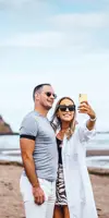 Couple taking a selfie on the beach at Pease Bay