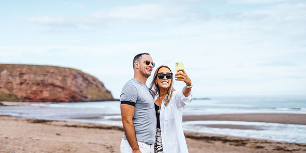 Couple taking a selfie on the beach at Pease Bay
