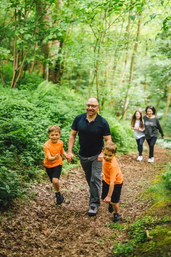 Family walking in forest at Coldingham Bay Leisure Park