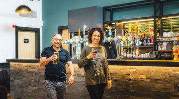 A couple collecting their drinks at the bar in The Drift Inn