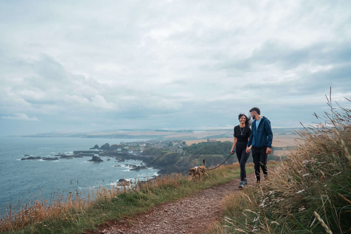 Couple walking along Berwickshire coastline