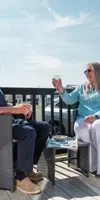Couple with drinks on lodge decking