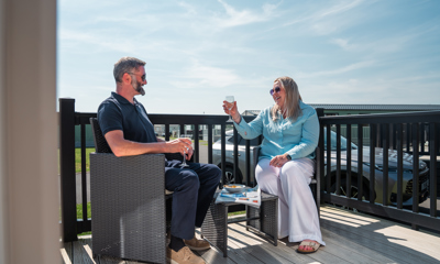 Couple with drinks on lodge decking