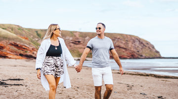 Couple walking on Pease Bay beach