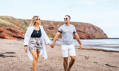 Couple walking on Pease Bay beach
