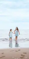 Children walking in the sea at Pease Bay