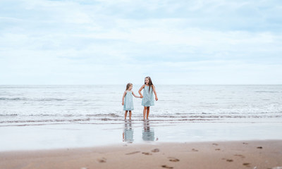 Children walking in the sea at Pease Bay