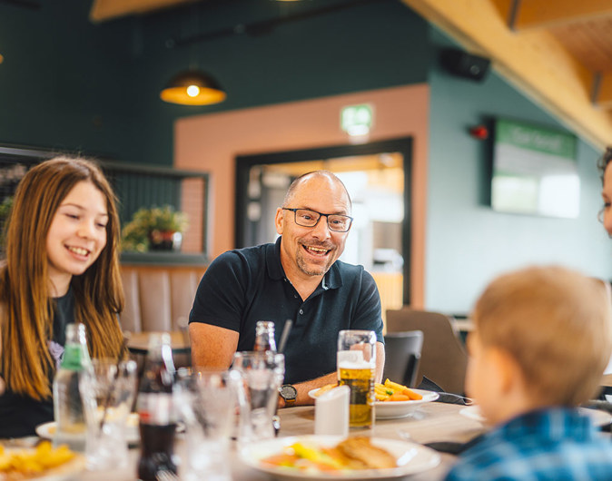 A family enjoying food and drinks indoors at The Drift Inn bar and restaurant 