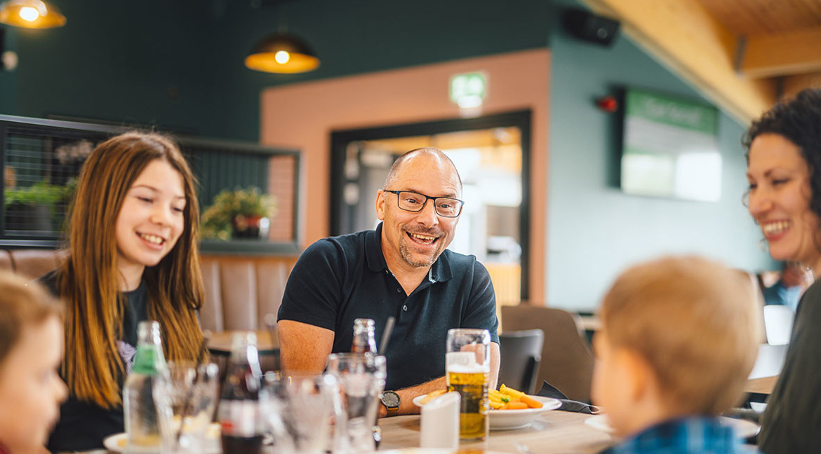 A family enjoying food and drinks indoors at The Drift Inn bar and restaurant